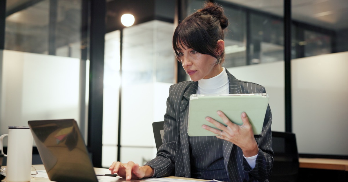 A woman in a business suit uses a tablet, discussing 2026 Medicare payment changes and key policy updates.